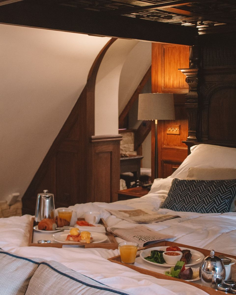 Breakfast tray on a four-poster bed in a heritage hotel room