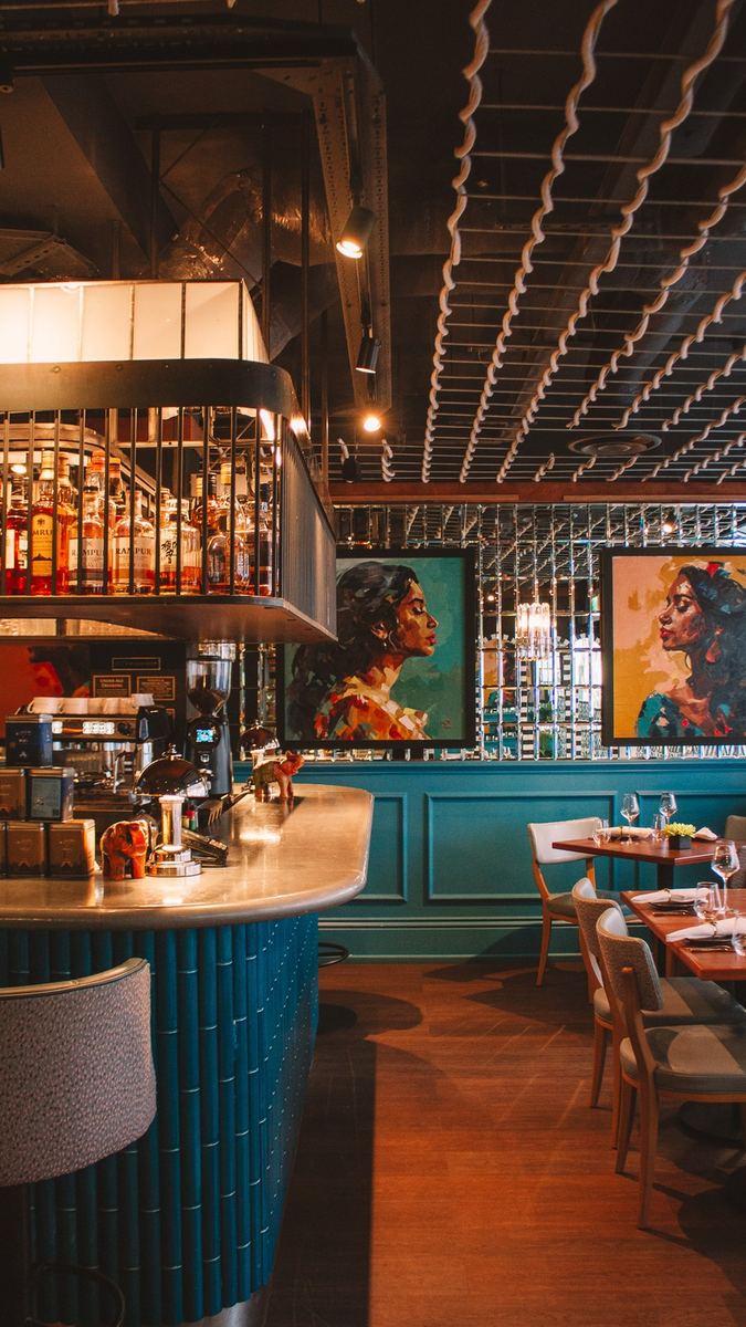 Kanishka's moody bar with patterned ceiling and portraits