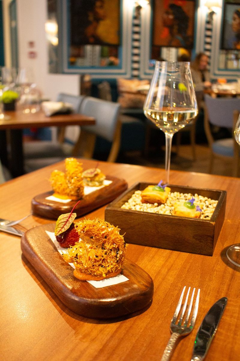 Indian fine dining small plates with a glass of white wine